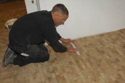 Rudi passt das letzte Parkettst�ck ein.  Fertig!