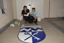 Jutta Jentges und Ihr Sohn Benno mit dem fertig verklebten Wappen.